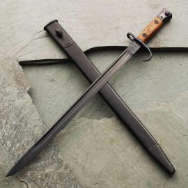 This is a reproduction SMLE No. 1, Mk III early style bayonet with scabbard. Originals are scarce; early in WWI quillions were officially removed. The blade, which includes British markings, is made from high carbon steel properly tempered for holding a razor edge. Sharpening is available for an additional fee. All metal has been deeply blued and the wood grips have a rubbed oil appearance.  The sheath is made with a leather body and sewn seam up the back with a lozenge style frog.  The top and tip are made from metal with a matte black finish. Made by Windlass Steelcrafts.    Overall: 22"  Blade: 17-1/4" x 1" x 3/16"  Wt: 1 lb/2 oz    